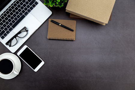 Workspace in office ,Black desk with blank notebook and other office supplies,Top view with copy...