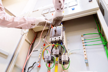 Technician is measuring voltage or current by voltmeter in control panel of power plan with...