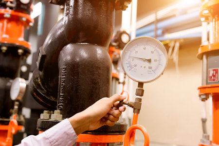 Engineer checking Condenser Water pump and pressure gauge , chiller water pump with pressure...