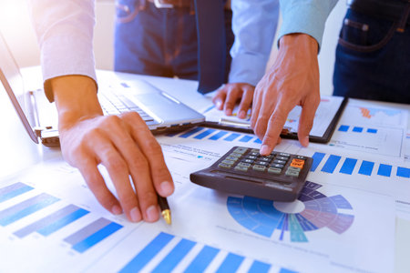 Business people negotiating a Contract, they are pointing on a document and discussing together, Two...