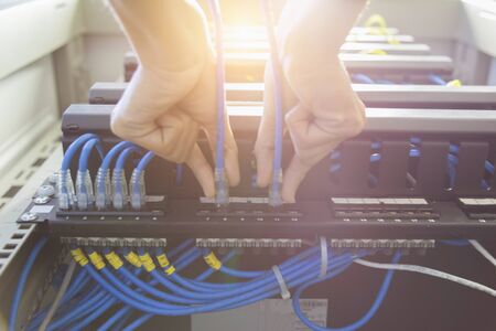 Technician connecting network cable to switchの写真素材