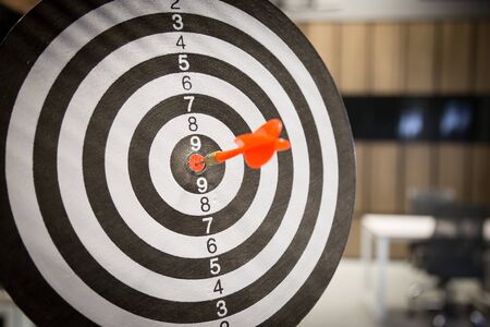 Red dart arrow hitting in the target center of dartboard on bullseye with sun light vintage style, Target marketing and business success concept - Image.の写真素材