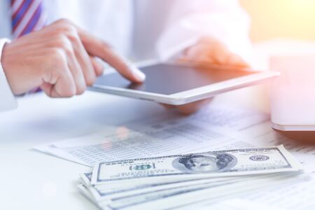 Businessman with cash dollars - business concept,tablet and finance,investment,save.の写真素材
