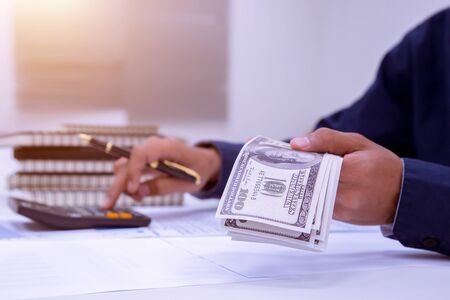 Business Financing Accounting Banking Concept, businessman using calculate about cost to real estate investment and in other, tax system.の写真素材