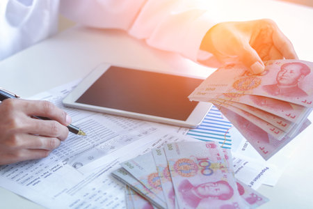 Businessman with cash yuan - business concept,tablet and finance,investment,save.