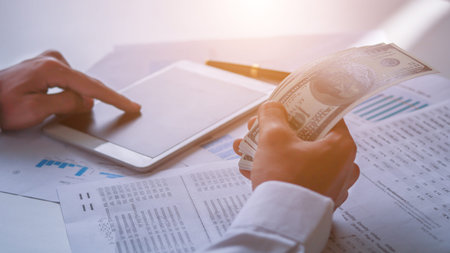 Businessman with cash dollars - business concept,tablet and finance,investment,save.