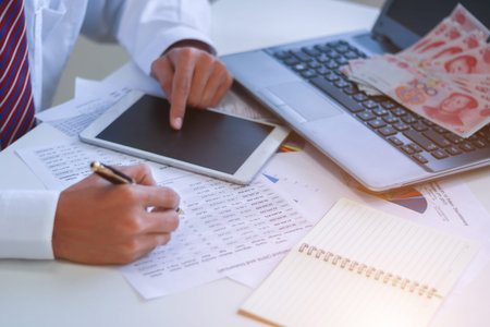 Businessman with cash yuan - business concept,tablet and finance,investment,save.