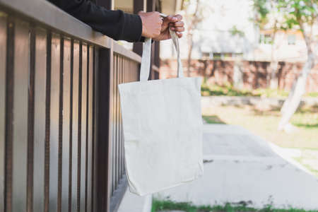 Man holding bag canvas fabric for mockup,ecology Concept.の写真素材