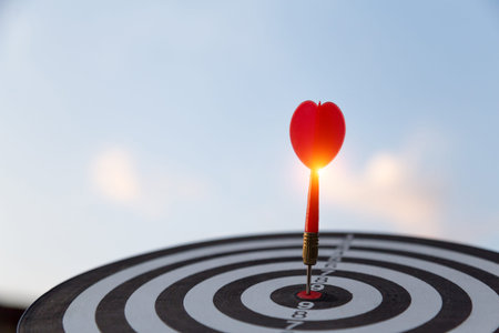 Red dart target arrow hitting on bullseye with,Target marketing and business success concept