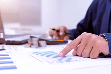 Midsection Of Businessman Calculating Tax Using Calculator In Office.の写真素材