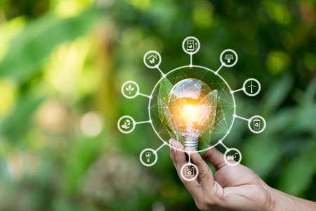 Hand holding light bulb with icons energy sources for renewable,love the world concept.の写真素材