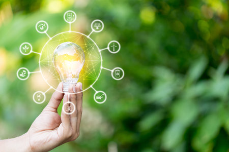Hand holding light bulb with icons energy sources for renewable,love the world concept.