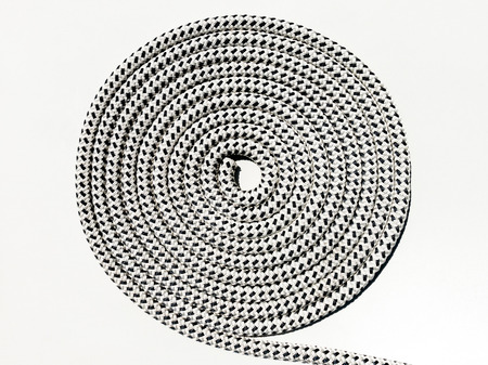 Braided polyester black and white marine rope coiled in a circle on deck of boatの写真素材