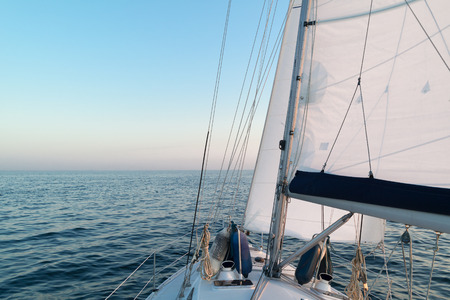 Sailing yacht cruising on North Sea alongside the Netherlands coast at twilight time on a summer...
