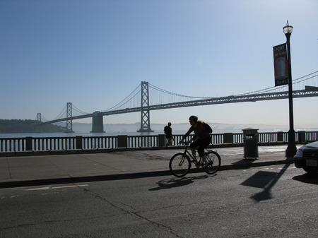 SAN FRANCISCO, CALIFORNIA, USA - APRIL 22, 2013: Bicyclist and Bay Bridge from The Embarcadero in San Francisco, Californiaのeditorial素材