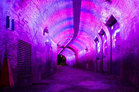 Purple and pink illuminated Ganzemarkt tunnel to Oudegracht in the old city centre of Utrecht, Netherlandsの写真素材
