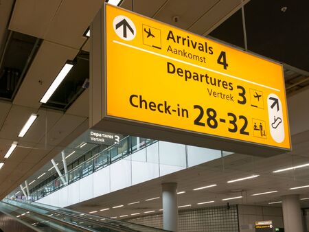 Direction signs and escalators in terminal of Schiphol Amsterdam Airport, Netherlandsの写真素材