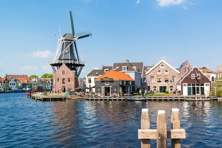 Waterfront cafe with people, windmill Adriaan and Spaarne river in Haarlem, Holland, Netherlandsのeditorial素材