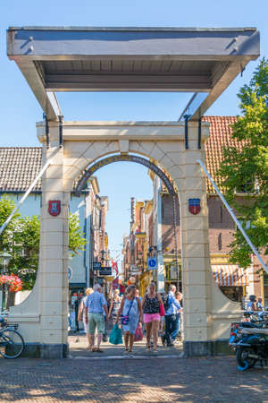 People walking on Bathbrug bridge to shopping street Fnidsen in Alkmaar, Netherlandsのeditorial素材