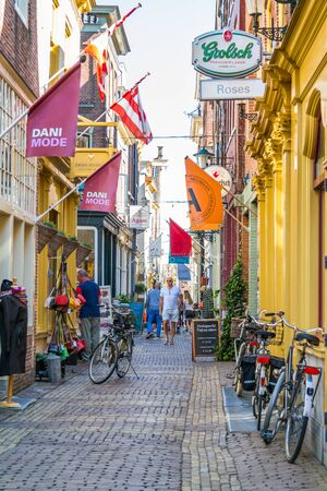 People walking and shops in small shopping street Fnidsen in Alkmaar, North Holland, Netherlandsのeditorial素材