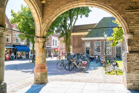 Bicycles and people shopping in Koorstraat from entrance arcades of Lawrence Church in Alkmaar, North Holland, Netherlandsのeditorial素材