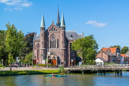 People in kayaks on Singelgracht canal and St. Joseph's Church in Alkmaar, Netherlandsのeditorial素材