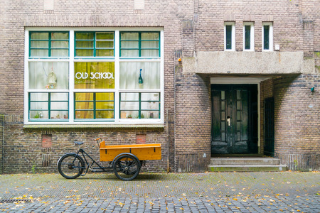 Cargo bike parked in front of old school building in downtown Leiden, South Holland, Netherlandsのeditorial素材