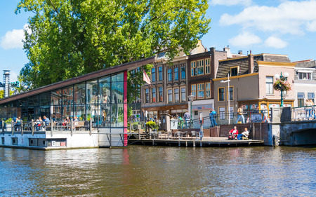 People on outdoor terrace of cafe on Galgewater canal in Leiden, South Holland, Netherlandsのeditorial素材