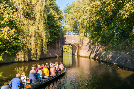 People in tourist boat on canal in autumn in old town of Naarden, North Holland, Netherlandsのeditorial素材