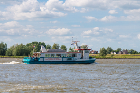 Ferry boat with people sailing on riverr Boven-Merwede from Woudrichem to Gorinchem, Netherlandsのeditorial素材
