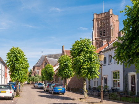 WOUDRICHEM, NETHERLANDS - JUN 4, 2017: Street scene Bagijnestraat with tower of Saint Martin's Church in centre of old fortified town of Woudrichem, Brabant, Netherlandsのeditorial素材