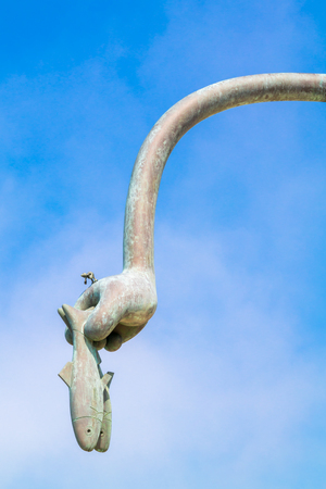 SCHEVENINGEN, NETHERLANDS - JUL 3, 2015: Hand with herring, detail of herring eater sculpture, part of Fairytales by the sea on boulevard of Scheveningen, The Hague, South Holland, Netherlandsのeditorial素材