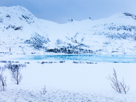 Winter scene with snow covered mountains and frozen lake Ternvatnan near Laukvik on Austvagoya, Lofoten islands, Nordland, Norwayの写真素材