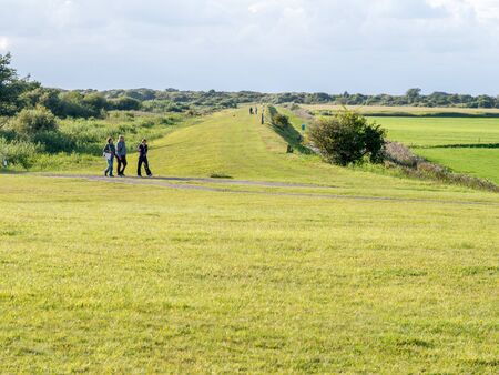 People walking on dike of West Frisian island Schiermonnikoog, Netherlandsのeditorial素材