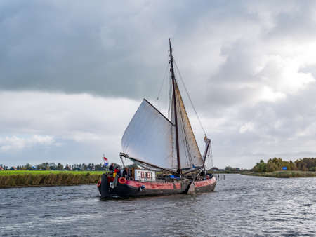 People sailing on traditional sailboat on Jeltesloot in De Fryske Marren, Friesland, Netherlandsのeditorial素材