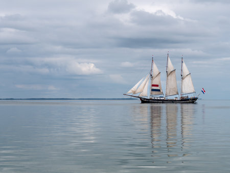 Traditional three-masted clipper sailing on calm IJsselmeer lake, Netherlandsのeditorial素材