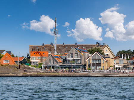Waterfront of East-Vlieland village with people relaxing on terrace from Waddensea, West Frisian...