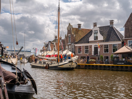 Sailboats motoring in Het Dok canal near Langestreek quay in old town of Lemmer, Friesland, Netherlandsのeditorial素材