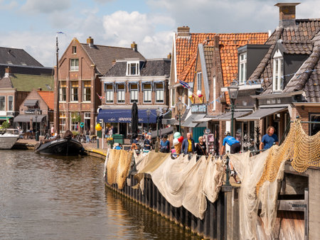 Oudesluis quay along Het Dok canal with shops in old buildings, Lemmer, Friesland, Netherlandsのeditorial素材