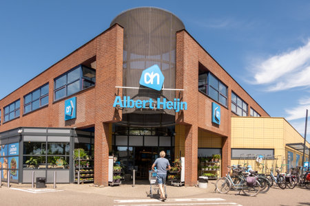 Man with cart goes grocery shopping at Albert Heijn in Medemblik, the leading supermarket chain in Netherlandsのeditorial素材