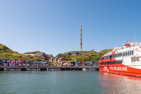 Promenade with wooden lobster shacks and ferry in harbour of Helgoland, island in German Bight, North Sea, Germanyのeditorial素材