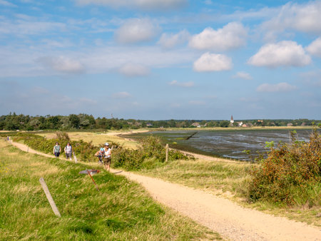 People walking on footpath along Wadden Sea on Amrum island, North Frisia, Schleswig-Holstein, Germanyのeditorial素材