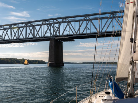 Sailboat sailing towards Old Little Belt Bridge connecting Jutland and Funen in Southern Denmark, Denmarkの写真素材