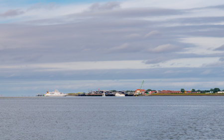 Panorama of ferry approaching Norderney harbor entrance from Wadden Sea, showing East Frisian island coastline in Lower Saxony, Germanyの写真素材