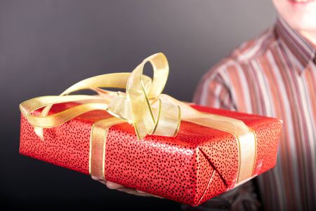 Man holds on a palm a gift in packing                  の写真素材