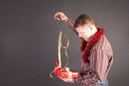 Man opens a gift in packing and unties a bow               の写真素材