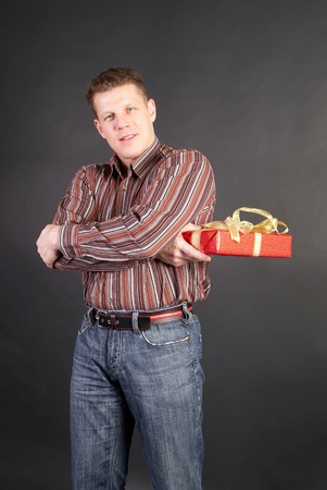 A man gets on the hip a red box with a gift                  の写真素材