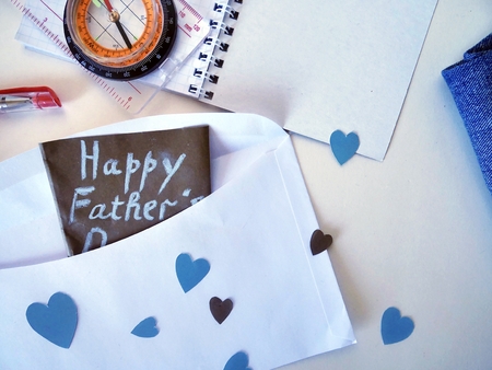 Greeting card for the day of the father, envelope with hearts from blue paper and tools