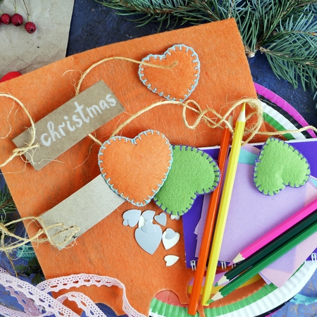 Christmas decor, branches of a Christmas tree, berries, felt hearts, art materials on a background of different textures, top view. Decorative seasonal composition, concept of preparation for the holidayの写真素材