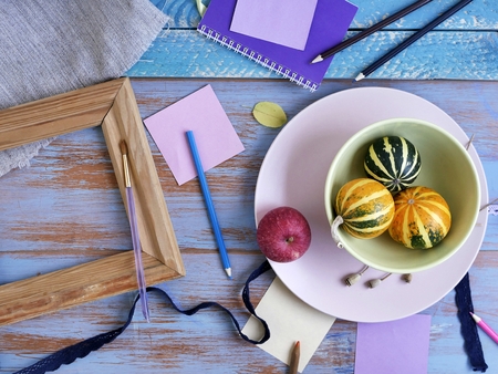 Autumn arrangement of decorative pumpkins, fresh flowers, leaves and art materials for the...